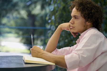 woman with book and pencil pondering